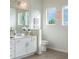 Bright bathroom featuring a large mirror, vanity, toilet and three adjacent sunny windows at 3881 Sonoma Blvd, Kissimmee, FL 34741