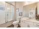Modern bathroom with a white vanity, a glass door shower over a tub, and wood-look tile flooring at 3881 Sonoma Blvd, Kissimmee, FL 34741
