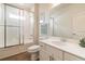Bright bathroom with white vanity, quartz countertops, shower with glass doors, and wood-look tile flooring at 3881 Sonoma Blvd, Kissimmee, FL 34741