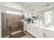 Bathroom featuring a glass-enclosed shower with stone floors, double vanity with white cabinets at 3881 Sonoma Blvd, Kissimmee, FL 34741