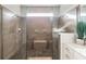 Bathroom showcasing a glass-enclosed shower with pebble floors and wood-like tile walls at 3881 Sonoma Blvd, Kissimmee, FL 34741