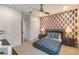Comfortable bedroom with geometric accent wall, ceiling fan, carpet, and neutral walls at 3881 Sonoma Blvd, Kissimmee, FL 34741