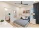 Beautiful bedroom with black and white bedding, a ceiling fan, and a bathroom accessible through an open door at 3881 Sonoma Blvd, Kissimmee, FL 34741