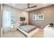Modern bedroom with neutral tones, featuring a unique bed frame, accent wall, and a stylish ceiling fan at 3881 Sonoma Blvd, Kissimmee, FL 34741