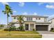 Beautiful two-story home with lush landscaping, modern design, and a well-manicured front lawn at 3881 Sonoma Blvd, Kissimmee, FL 34741