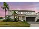 Stunning two-story home showcasing modern architecture and lush landscaping, complete with a palm tree at 3881 Sonoma Blvd, Kissimmee, FL 34741