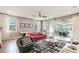 Spacious living room with a sleek interior design, a comfortable red sofa, and a view of the outdoor seating area at 3881 Sonoma Blvd, Kissimmee, FL 34741