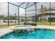 Relaxing hot tub overlooking sparkling pool within an enclosed screened-in pool area in a landscaped backyard at 3881 Sonoma Blvd, Kissimmee, FL 34741