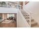 Open staircase leading to a living area with hardwood floors and comfortable furnishings at 3881 Sonoma Blvd, Kissimmee, FL 34741