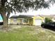 Charming yellow single-story home with a well-manicured lawn and attached one car garage at 1018 Martin Blvd, Orlando, FL 32825