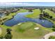 Scenic aerial view of community golf course with a tranquil lake, lush fairways, and manicured greens at 10257 Henbury St, Orlando, FL 32832