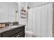 Well-lit bathroom featuring a granite-topped vanity, decorative shelving, and shower-tub combination at 10257 Henbury St, Orlando, FL 32832