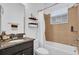 Well-lit bathroom with a granite-topped vanity, tiled shower-tub combination, and decorative shelving at 10257 Henbury St, Orlando, FL 32832