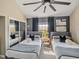 This bedroom features twin beds, ceiling fan, closet, neutral gray tones and plenty of natural light at 1174 Villa Ln # 115, Apopka, FL 32712