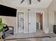 This bedroom features a wall mounted TV, neutral gray tones, next to a half bath, and stairway at 1174 Villa Ln # 115, Apopka, FL 32712