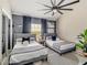 Comfortable bedroom featuring two beds with modern decor, sleek ceiling fan, and neutral colors at 1174 Villa Ln # 115, Apopka, FL 32712