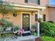 Close-up of front door adorned with seasonal decor, enhanced by beautiful landscaping and potted plants at 1174 Villa Ln # 115, Apopka, FL 32712