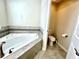 Bathroom featuring corner soaking tub and separate toilet room at 11810 Imaginary Way, Orlando, FL 32832