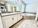 Bathroom featuring double sink vanity and a corner soaking tub with tile surround at 11810 Imaginary Way, Orlando, FL 32832