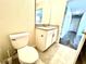 Bright bathroom featuring a toilet, white vanity with sink, and tile flooring at 11810 Imaginary Way, Orlando, FL 32832