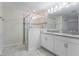 Bright bathroom featuring dual sinks, a large mirror, and a modern glass-enclosed shower at 11810 Imaginary Way, Orlando, FL 32832
