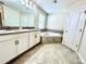 Bathroom featuring double sink vanity and a corner soaking tub with tile surround at 11810 Imaginary Way, Orlando, FL 32832