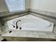 Corner soaking tub with stylish tile surround and modern faucet at 11810 Imaginary Way, Orlando, FL 32832