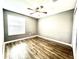 An empty bedroom with wood-look flooring, a ceiling fan, and window with blinds at 11810 Imaginary Way, Orlando, FL 32832