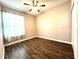 An empty bedroom with wood-look floors, a ceiling fan, and a window with curtains at 11810 Imaginary Way, Orlando, FL 32832