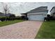 Spacious brick driveway leading to a two-car garage and a screened in back porch at 11810 Imaginary Way, Orlando, FL 32832