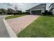 Paver driveway leads to an attached garage, complemented by lush green grass at 11810 Imaginary Way, Orlando, FL 32832