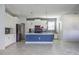 Spacious kitchen with stainless steel appliances, white cabinets and a gray backsplash with a blue island at 11810 Imaginary Way, Orlando, FL 32832