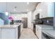 Bright kitchen with stainless steel appliances, white cabinetry, granite countertops, and a center island at 11810 Imaginary Way, Orlando, FL 32832
