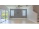 Living room with tile flooring, a ceiling fan, two windows, and a sliding glass door to the patio at 11810 Imaginary Way, Orlando, FL 32832