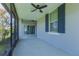 Covered patio with blue shutters, ceiling fan, and sliding glass doors at 11810 Imaginary Way, Orlando, FL 32832
