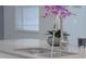 Close-up of a modern kitchen sink with a sleek faucet and granite countertop with decorative plant at 11810 Imaginary Way, Orlando, FL 32832