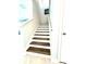 A staircase with wood-look steps and white risers, with a white railing at 11810 Imaginary Way, Orlando, FL 32832