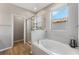 Bathroom featuring a separate shower, tub, and large window at 11980 Sands Cv, Orlando, FL 32828