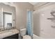 Bathroom features a shower-tub combination with blue patterned curtain and a granite countertop sink at 11980 Sands Cv, Orlando, FL 32828