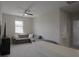 Bonus room features a plush sofa, ceiling fan and a window, offering comfortable additional living space at 11980 Sands Cv, Orlando, FL 32828