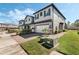 Two-story townhome boasts a brick-paved driveway, a two-car garage, and manicured landscaping at 11980 Sands Cv, Orlando, FL 32828