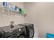 Modern laundry room features black Samsung washer and dryer, plus wire shelving for storage at 11980 Sands Cv, Orlando, FL 32828