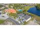 Aerial view of a property close to a pond and amenities, including a pool and clubhouse at 1205 Butterfly Orchid Rd, Davenport, FL 33837