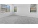 Bright bedroom with plush gray carpet, three windows with blinds, and neutral paint at 1205 Butterfly Orchid Rd, Davenport, FL 33837
