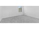 An empty room features plush neutral carpet and a large window at 1205 Butterfly Orchid Rd, Davenport, FL 33837