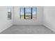 An empty room with neutral carpet and large windows offers plenty of natural light at 1205 Butterfly Orchid Rd, Davenport, FL 33837