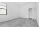 A minimalist bedroom with a gray carpet, a window with blinds, and a walk-in closet at 1205 Butterfly Orchid Rd, Davenport, FL 33837