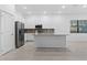 Clean kitchen with white cabinets, modern appliances, tile backsplash, and an island at 1205 Butterfly Orchid Rd, Davenport, FL 33837