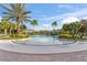Large community pool with spacious sun deck, lush landscaping, sun umbrellas, and nearby clubhouse, offering a relaxed setting at 1205 Butterfly Orchid Rd, Davenport, FL 33837