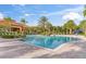 Beautiful community pool area featuring a large pool, lounge chairs, lush tropical landscaping, and nearby clubhouse at 1205 Butterfly Orchid Rd, Davenport, FL 33837